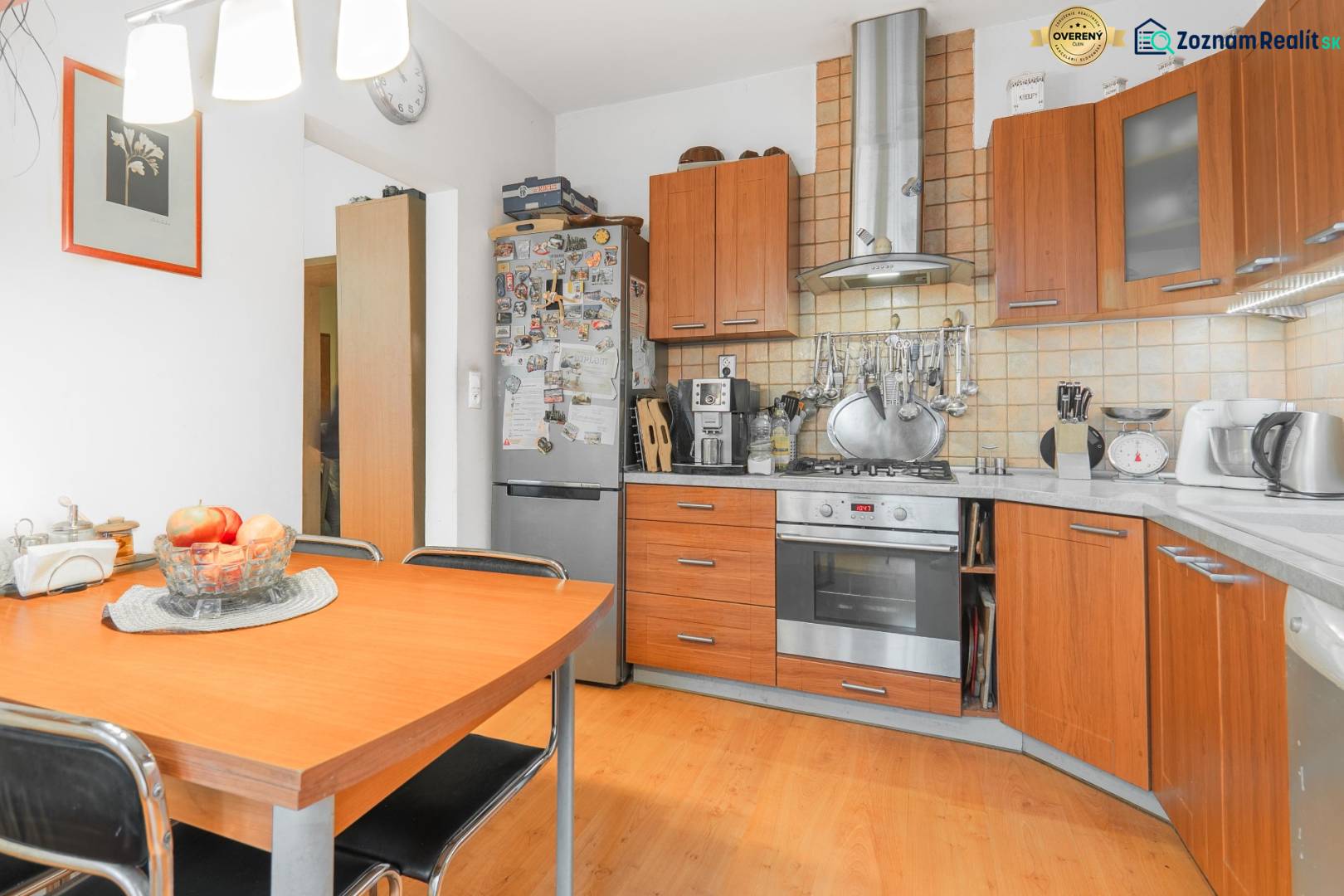 A kitchen in a 4-room apartment with a wooden decor floor and wooden cabinets.