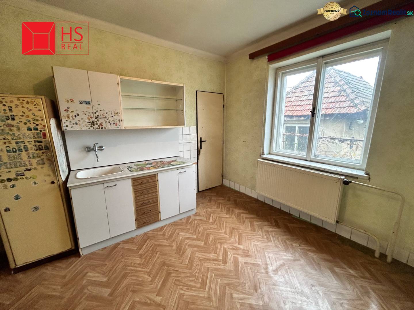 A kitchen in a family house with a wooden decor floor and a simple kitchen unit.