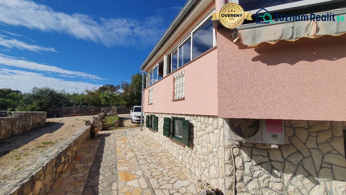 A family house in Pridraga with stone cladding, a driveway, and a garden.