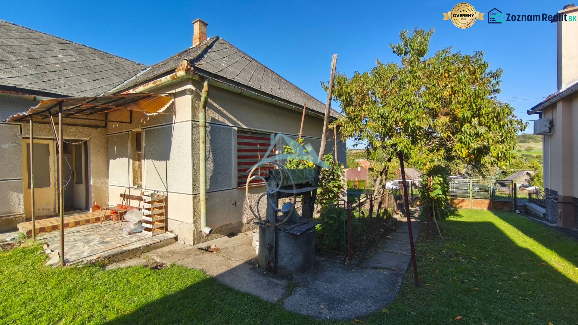 A family house in Čebovce with a yard, a tree, and an old well in the green garden.