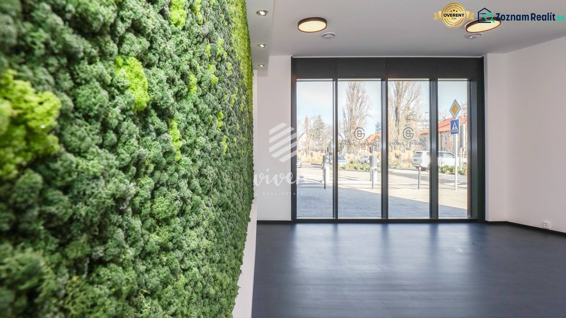 Commercial spaces with a vertical garden and large windows, allowing a view of the street.