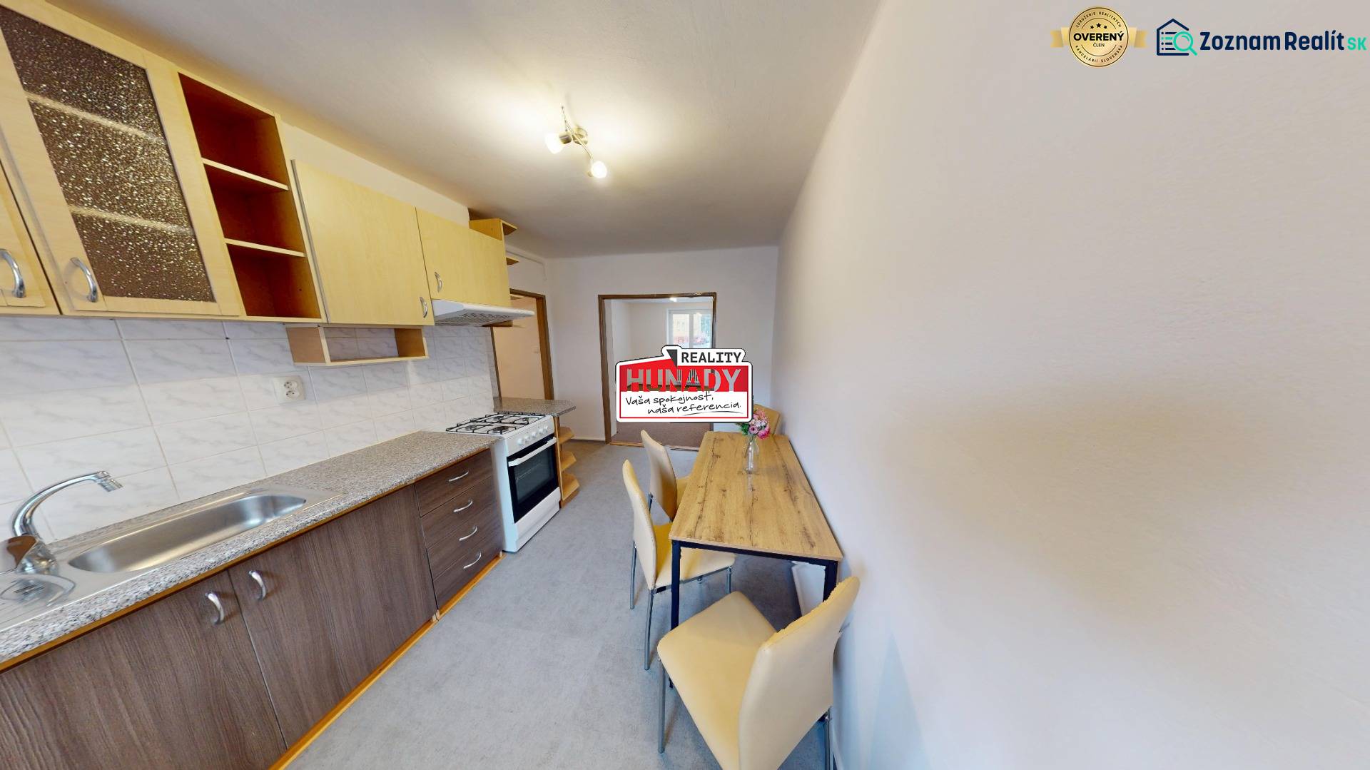 A kitchen in a 2-room apartment with a kitchenette, seating area, and cooking zone.