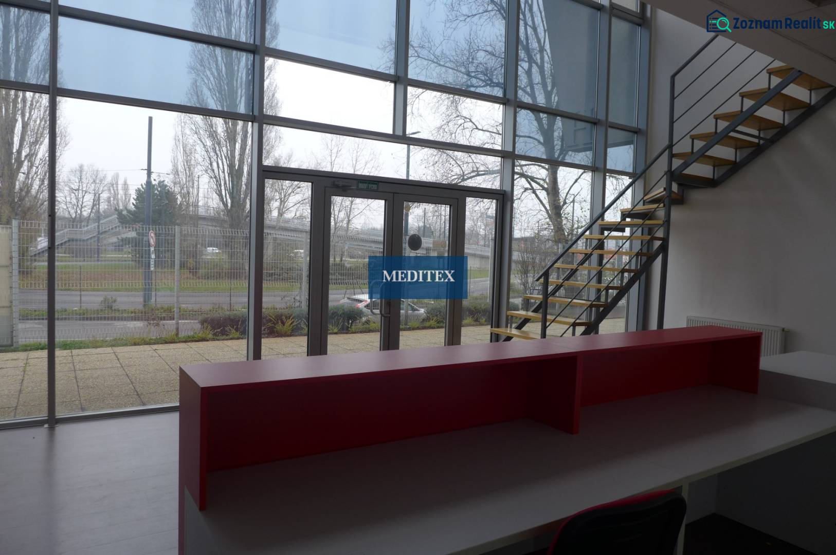 Reception with a staircase and large windows in commercial premises.