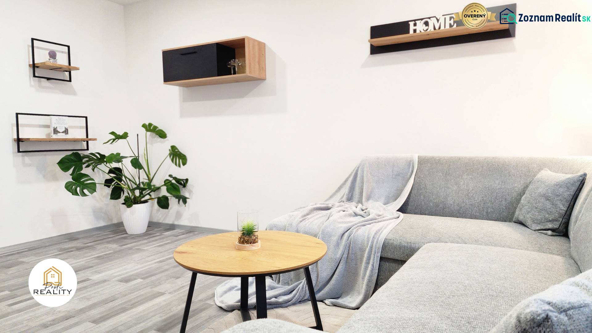Living room in a two-room apartment with a wooden decor floor and a comfortable sofa.
