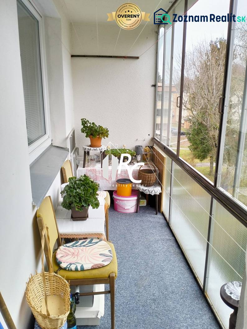 A glazed balcony with flowers and a chair, 3-room apartment.