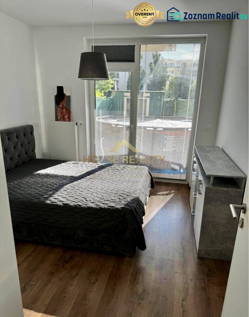 Bedroom in a 3-room apartment with a bed, window with blinds, and flooring with a wooden decor.