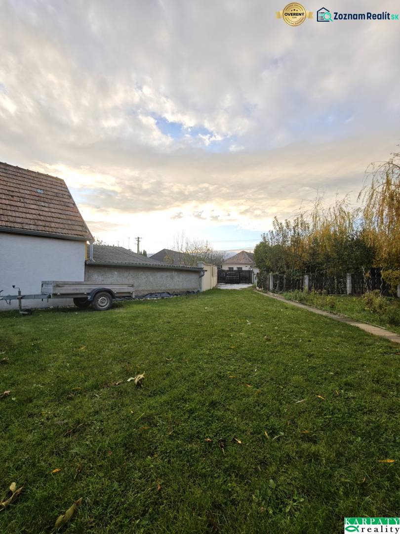 A family house on Krátka Street in Blatné with a grassy yard and a trailer.
