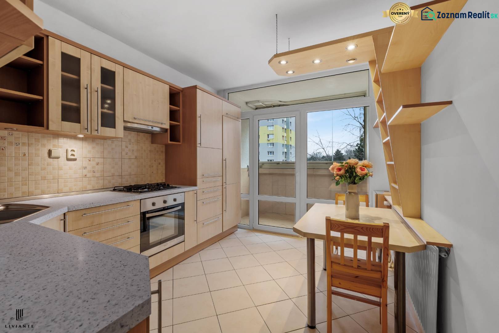 A kitchen with wooden cabinets, a stove, and a dining table for a 4-room apartment.