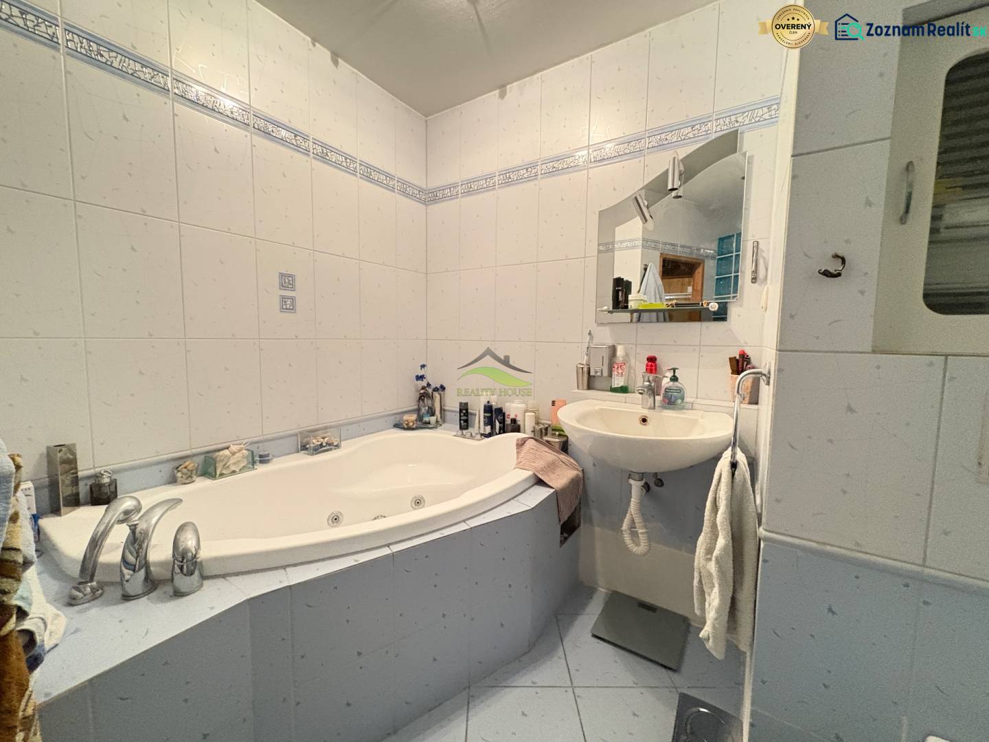 A bathroom with a corner bathtub and a sink in a 3-room apartment.