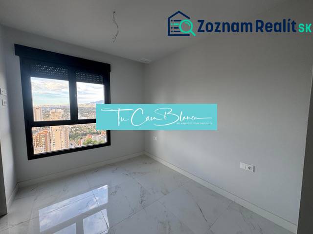 An empty room with a bright floor and a view in a 3-room apartment with marble.