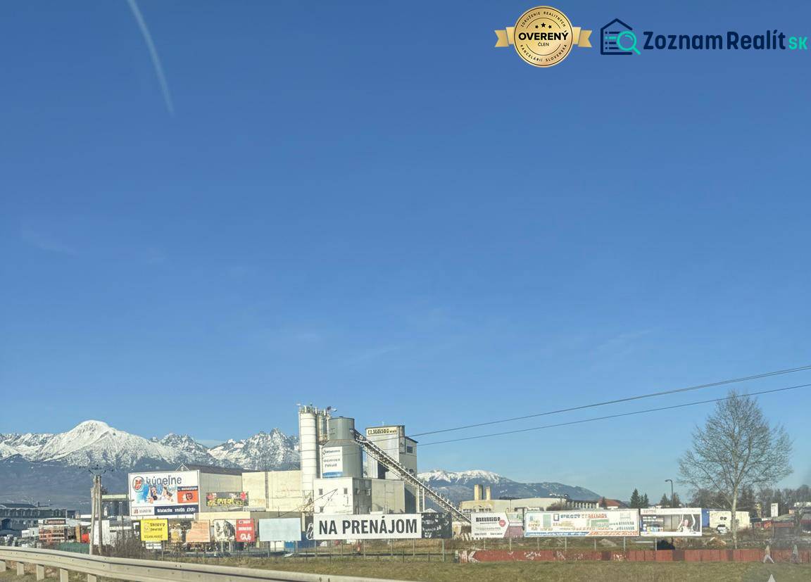 Commercial spaces in Poprad with a backdrop of snow-covered mountains and a clear sky.
