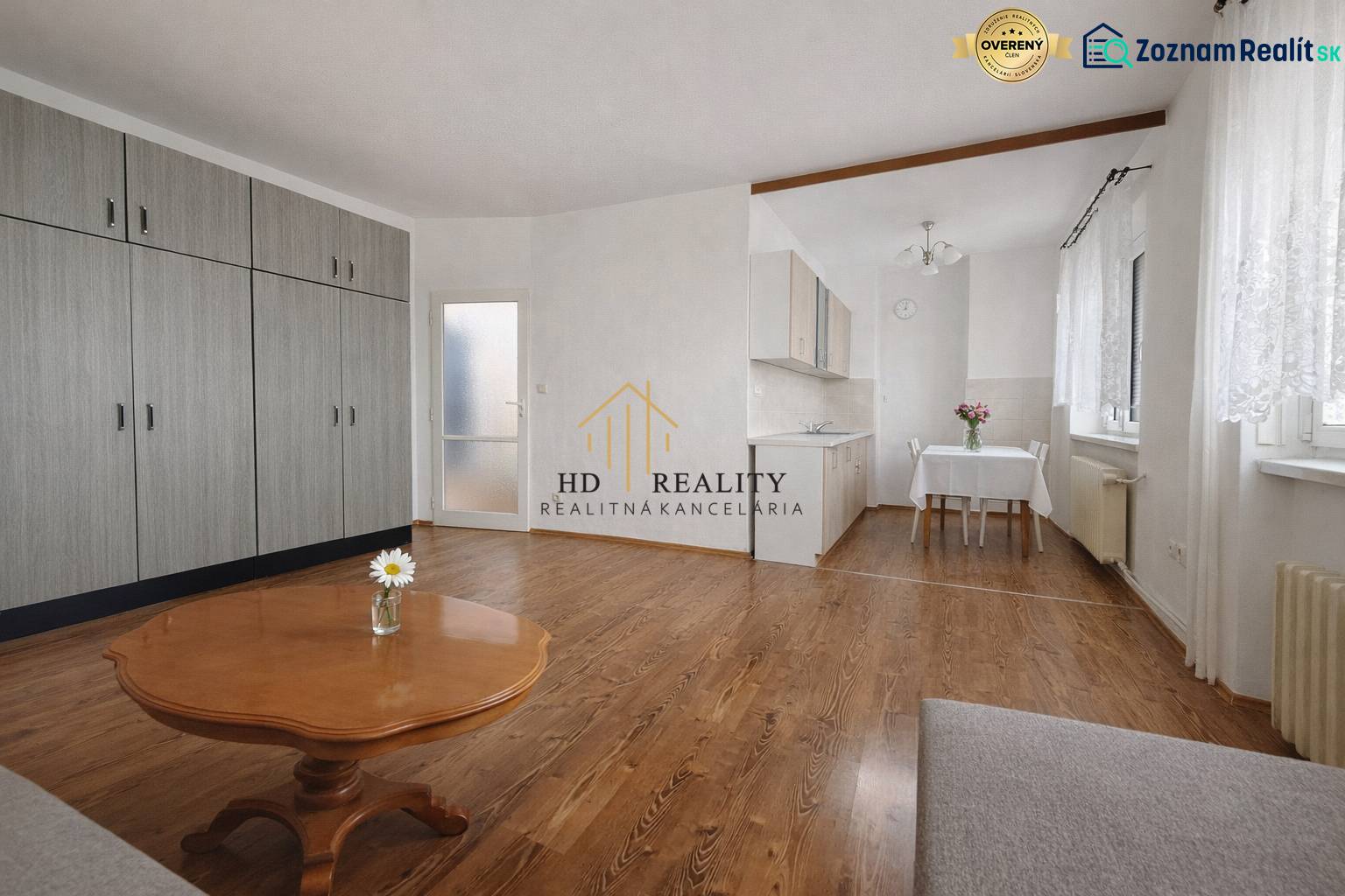 1-bedroom apartment with wood-patterned flooring, built-in wardrobes, and a kitchenette.