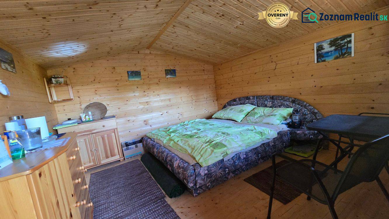 Interior of a wooden cabin with a double bed, a wardrobe, and wall decorations.