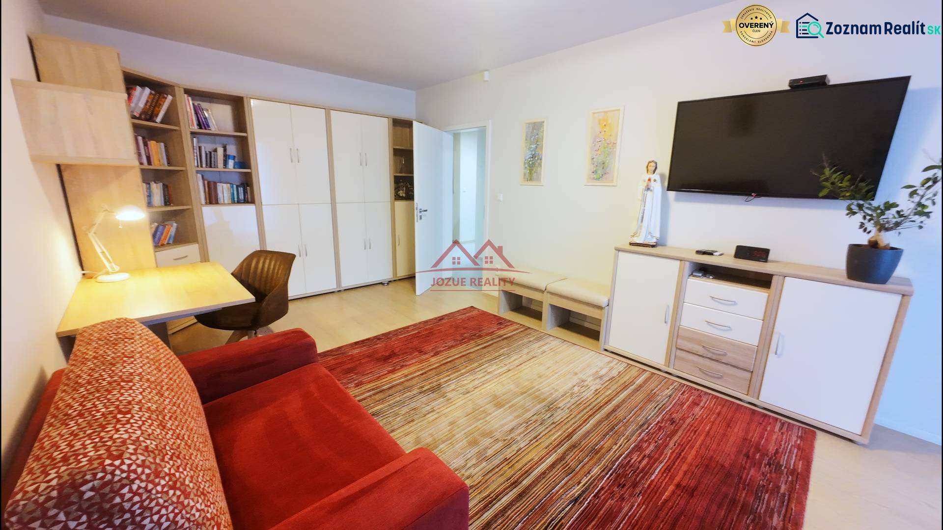 Living room in a 4-room apartment with a comfortable sofa, television, and a work desk.