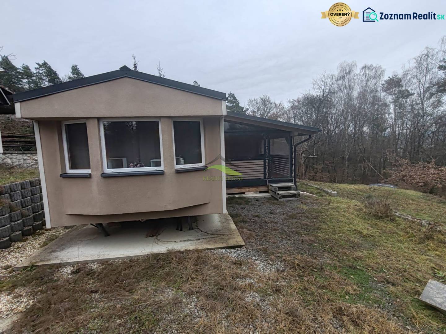 A cottage on Main Street in Nova Kelca surrounded by trees and gently sloping terrain.