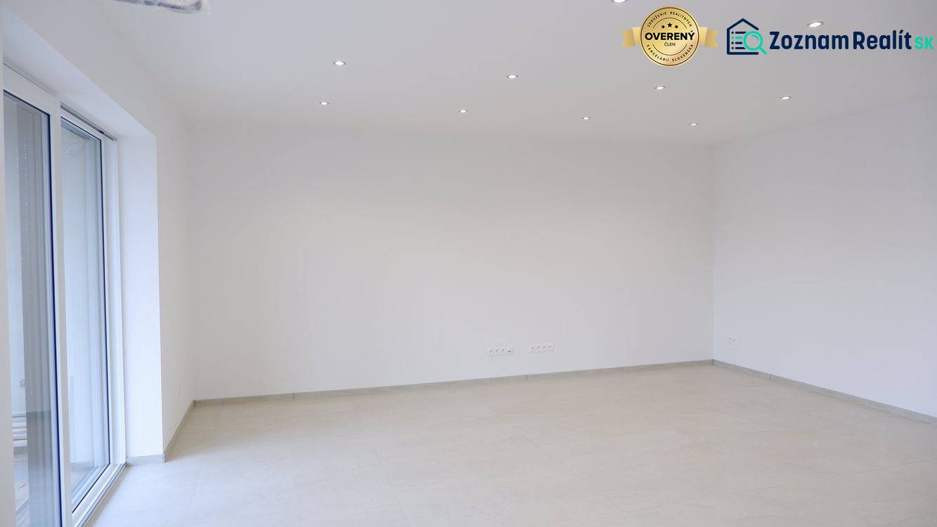 An empty room in a family house with white walls and a light floor.