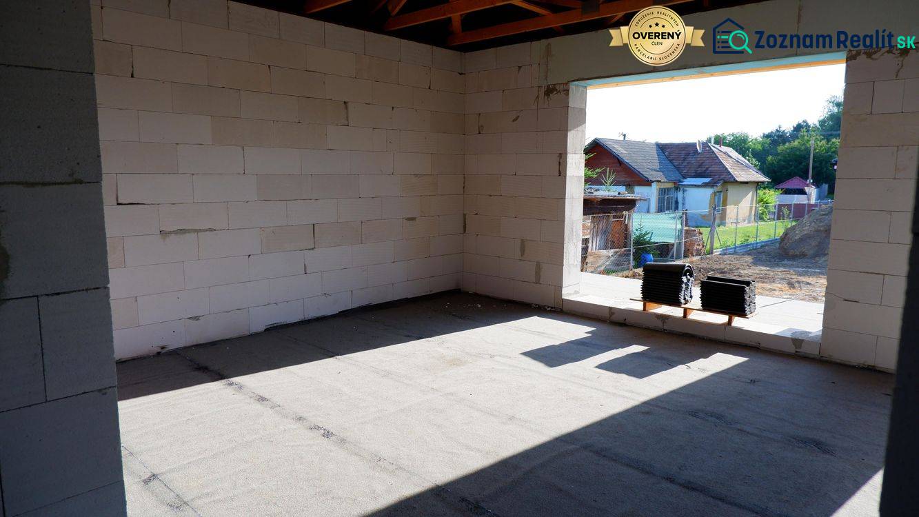 Construction of a family house in Radava with a view of the unfinished walls and the surrounding landscape.