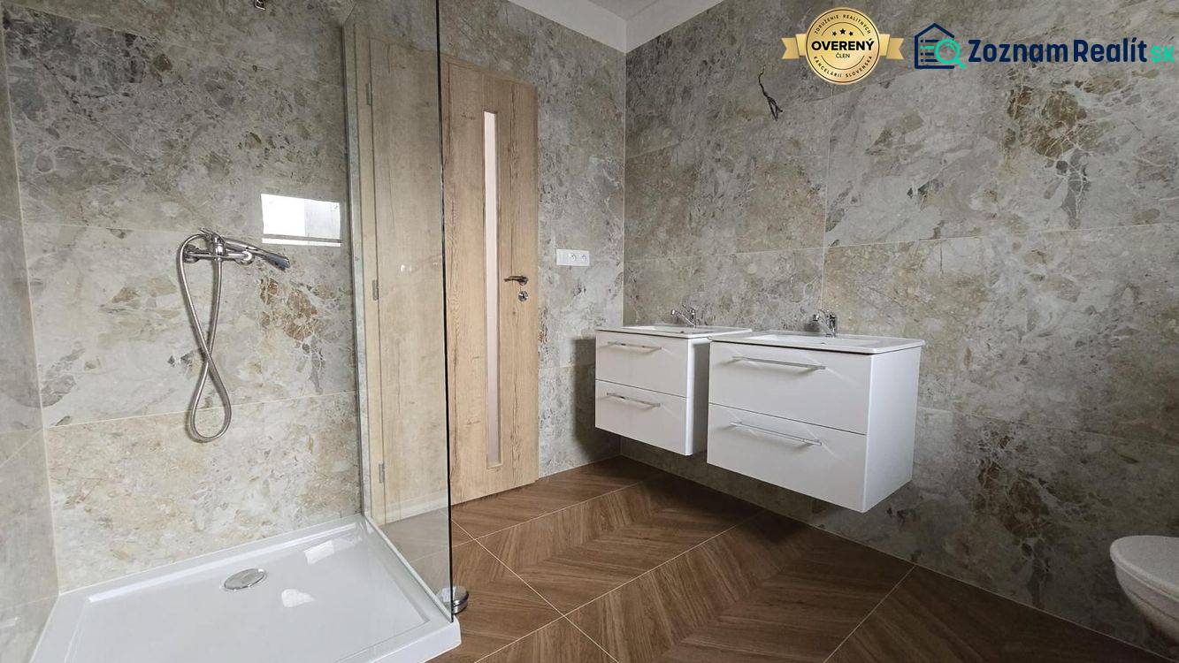 A bathroom in a family house with stone cladding and a shower enclosure.