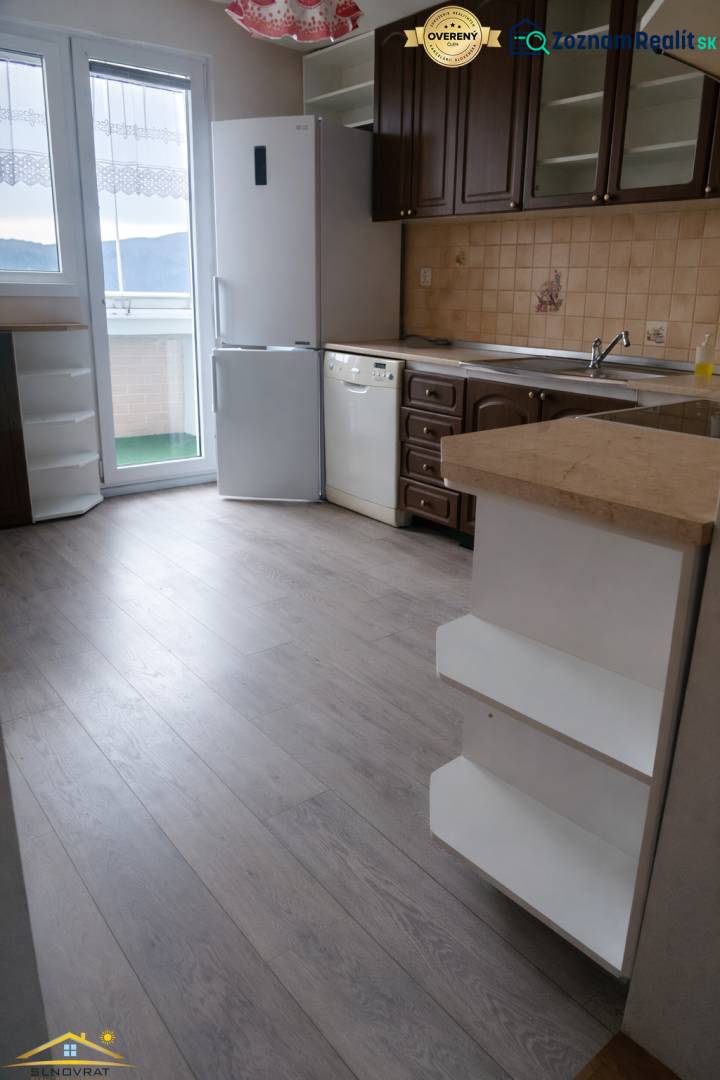 A kitchen in a 3-room apartment with a wooden decor floor, a white refrigerator, and a dishwasher.