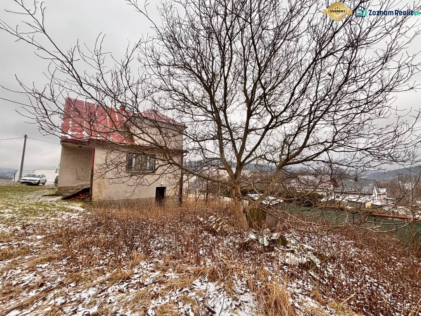 A family house in Poľana in Skalité without foliage, with the surroundings covered in light snow.