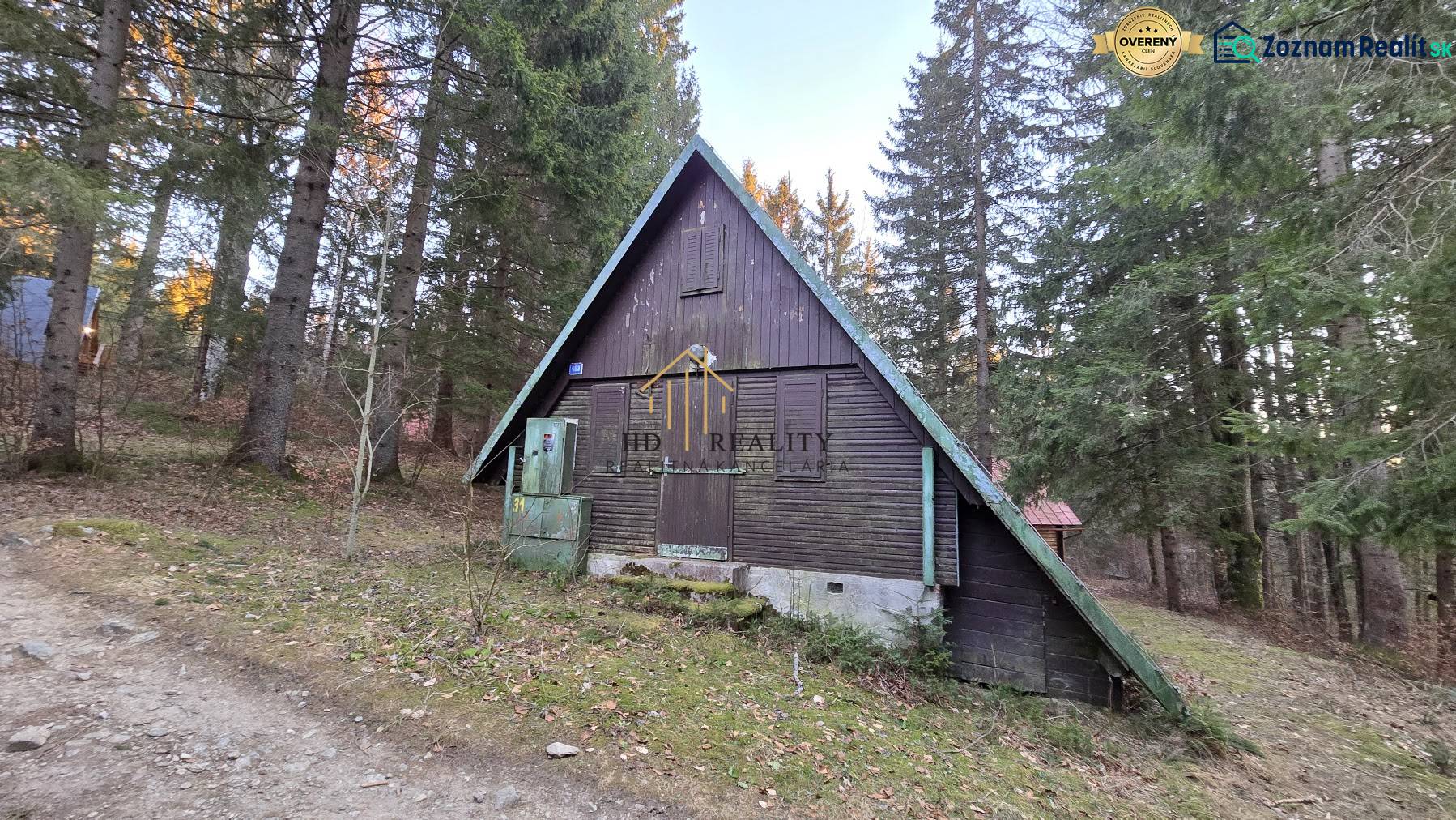 A cottage in Krpáčovo nestled in the forest, showing a wooden structure and surroundings with coniferous trees.