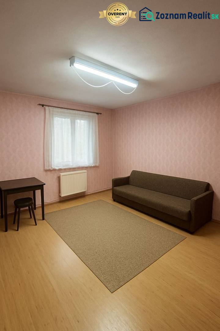 A room in a family house with a brown couch, a table, and a floor with a wooden decor.