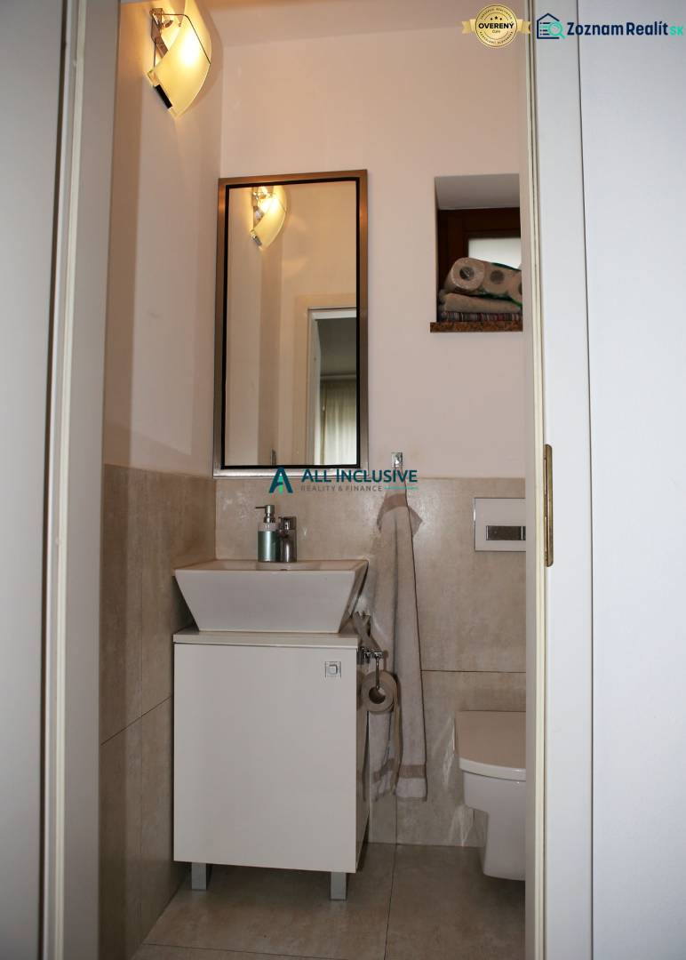 Bathroom with beige walls in a family house, with a sink and a mirror.