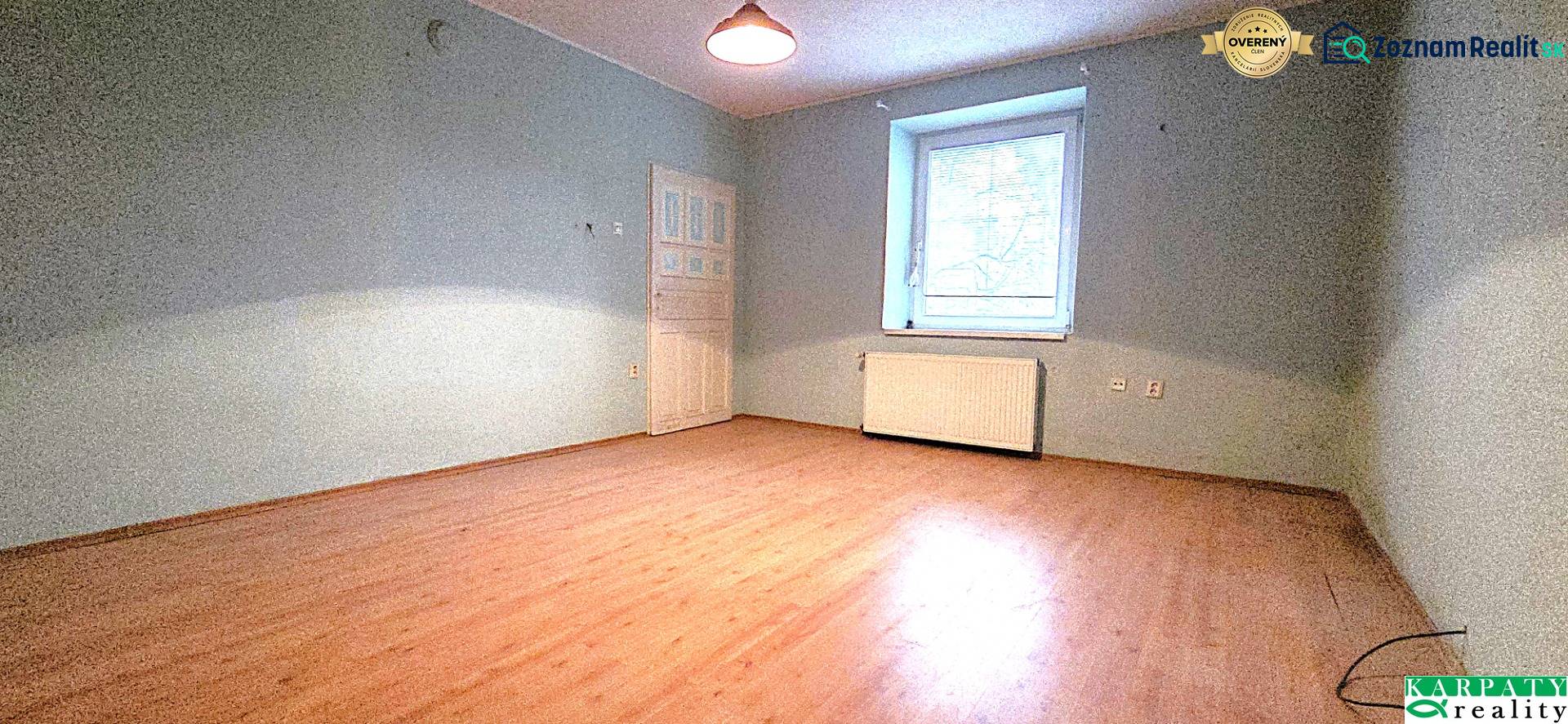 A room in a family house with a wooden decor floor and blue walls.