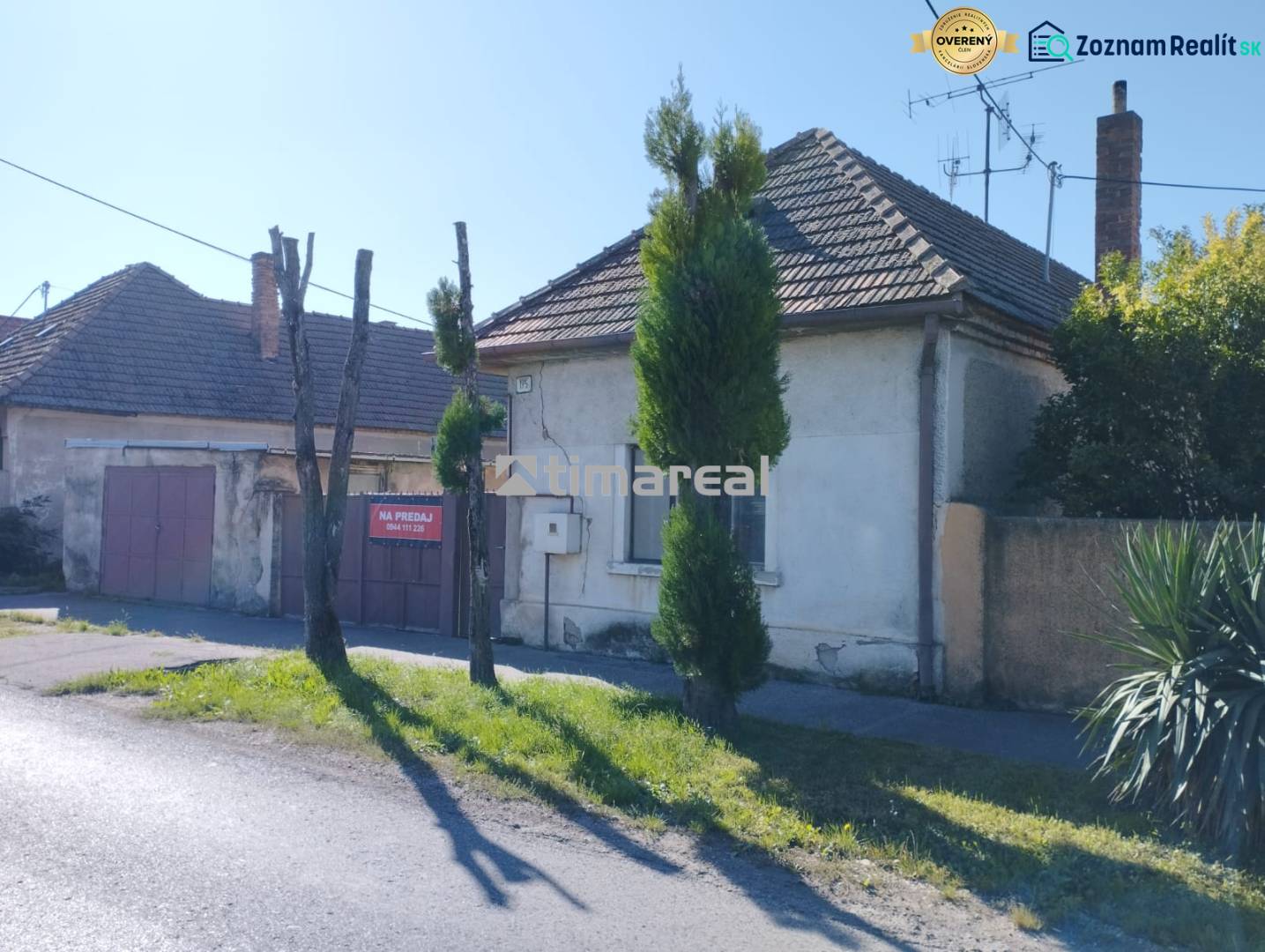 A family house in Reca with a wooden gate and a stone fence.