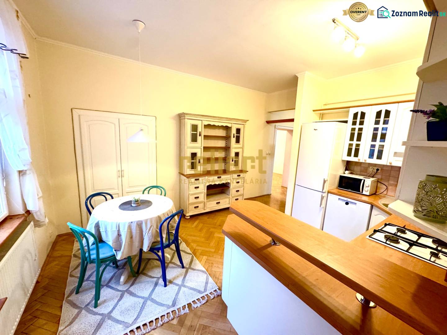 Dining room in a 4-room apartment with a round table and wooden decor flooring.