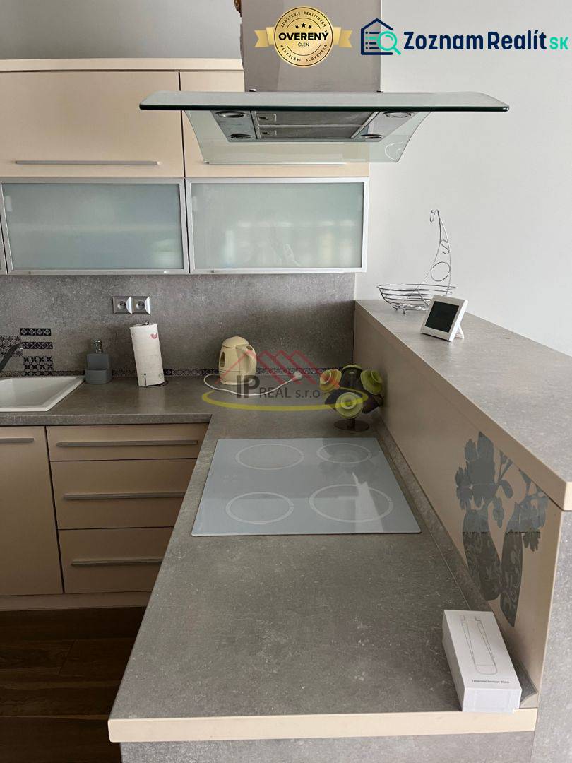 A kitchen unit in a 4-room apartment with an induction cooktop and a range hood.