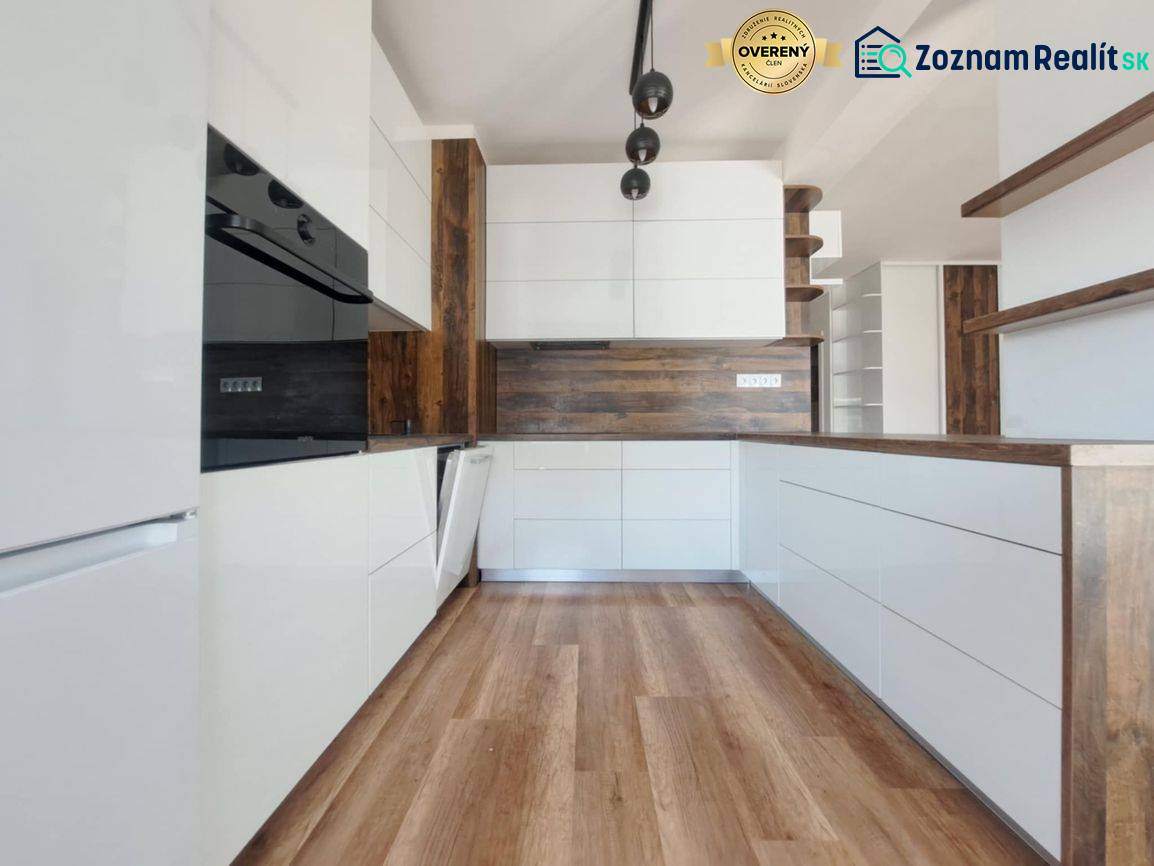 A kitchen in a 2-room apartment with white cabinets and a wood-patterned floor.