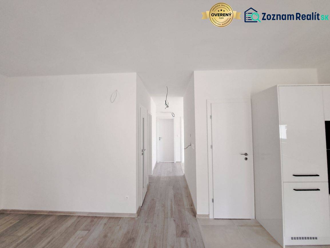 A bright interior of a family house with a wood-patterned floor and white walls.