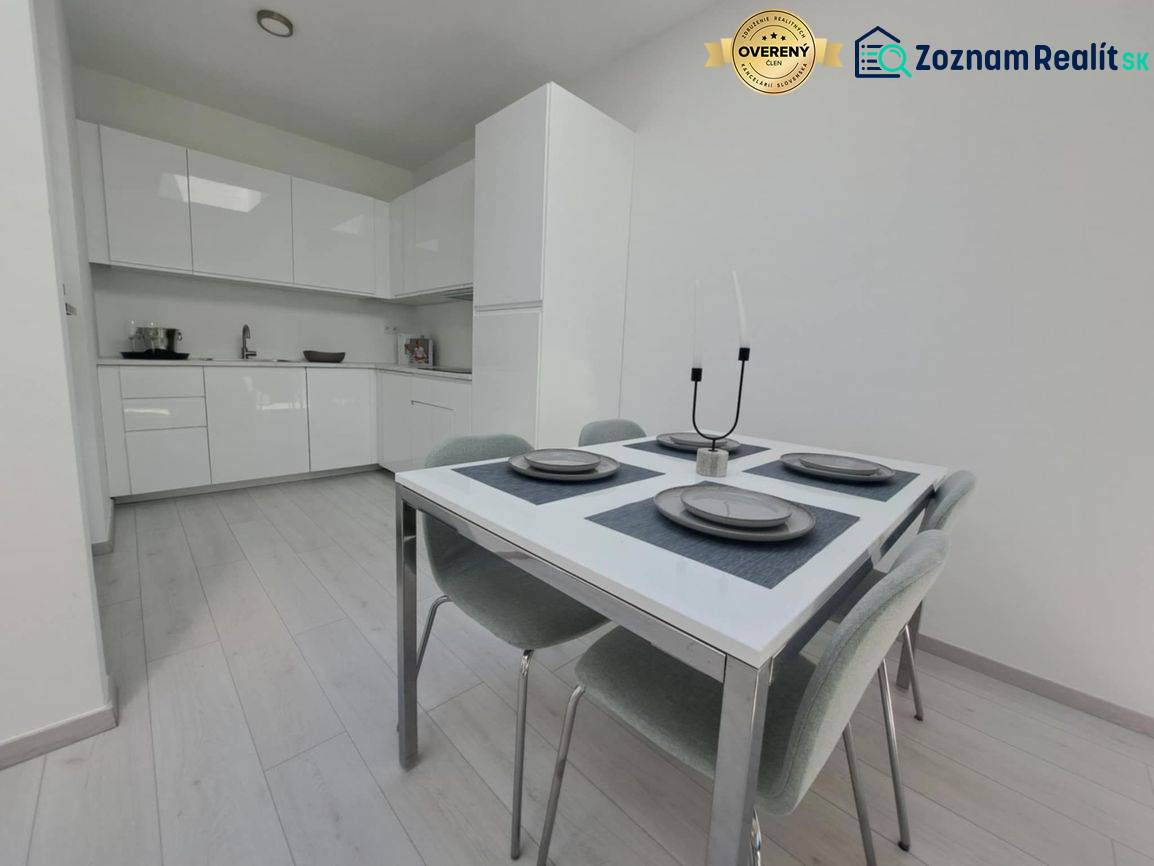 Dining area in a 2-room apartment with a kitchen unit and flooring with a wood decor.