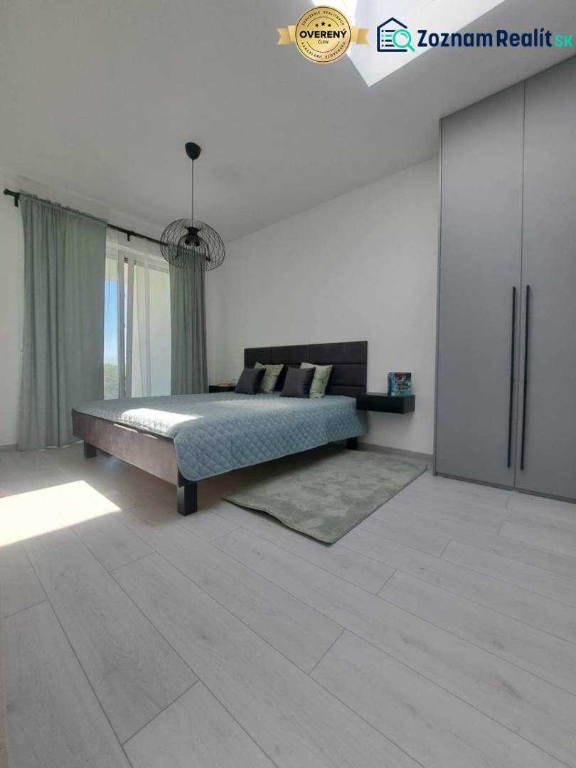Bedroom in a 2-room apartment with wood-patterned flooring and sliding doors.