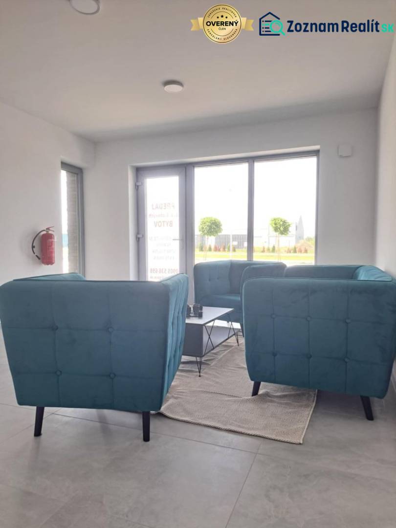 Blue chairs, coffee table, white walls, light flooring, interior of commercial premises.