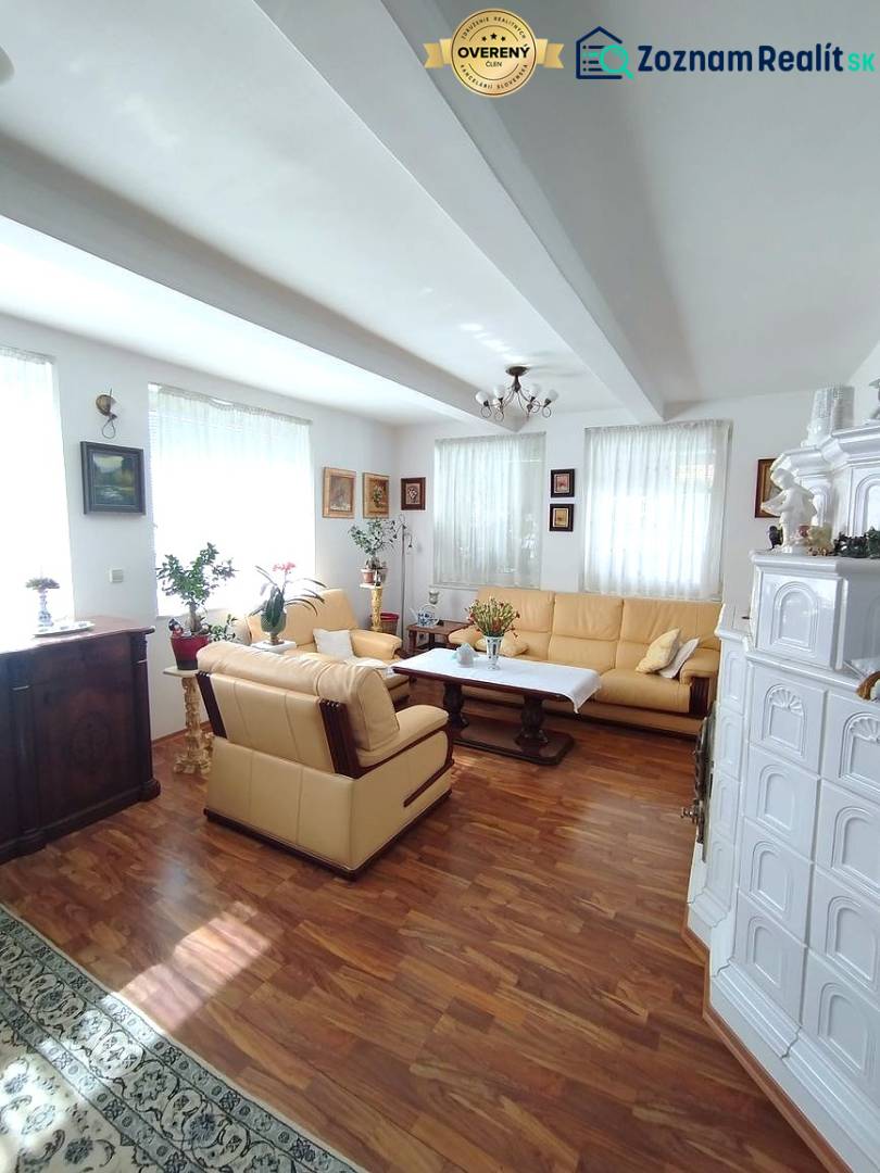 Living room of a family house with a wooden-patterned floor, a fireplace, and a comfortable sofa set.