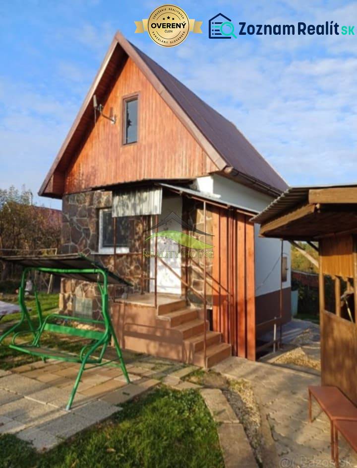 A cottage in Pozdišovce with wooden cladding and a swing in the garden.
