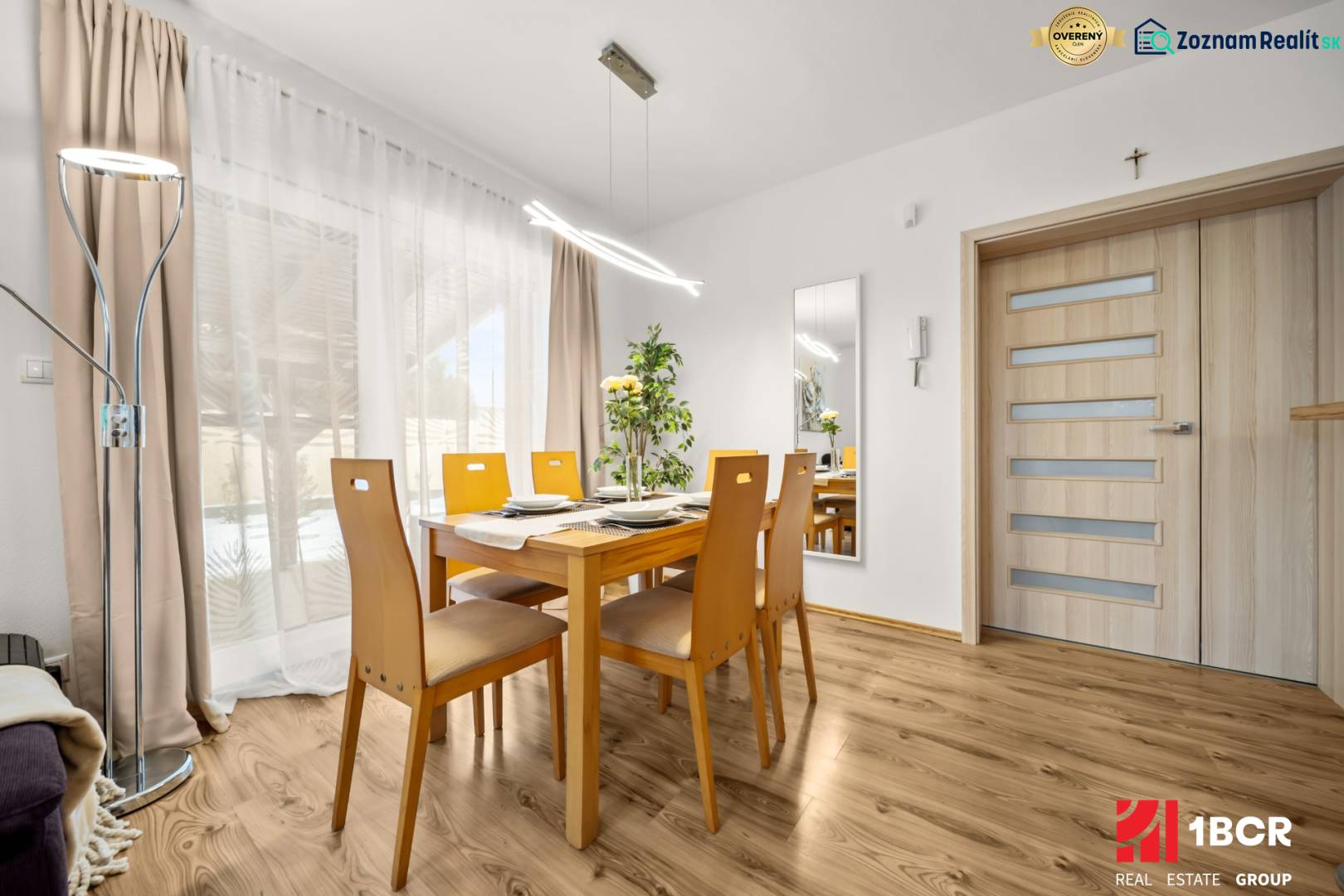 A dining room with a wooden table and a wooden decor floor in a family house.