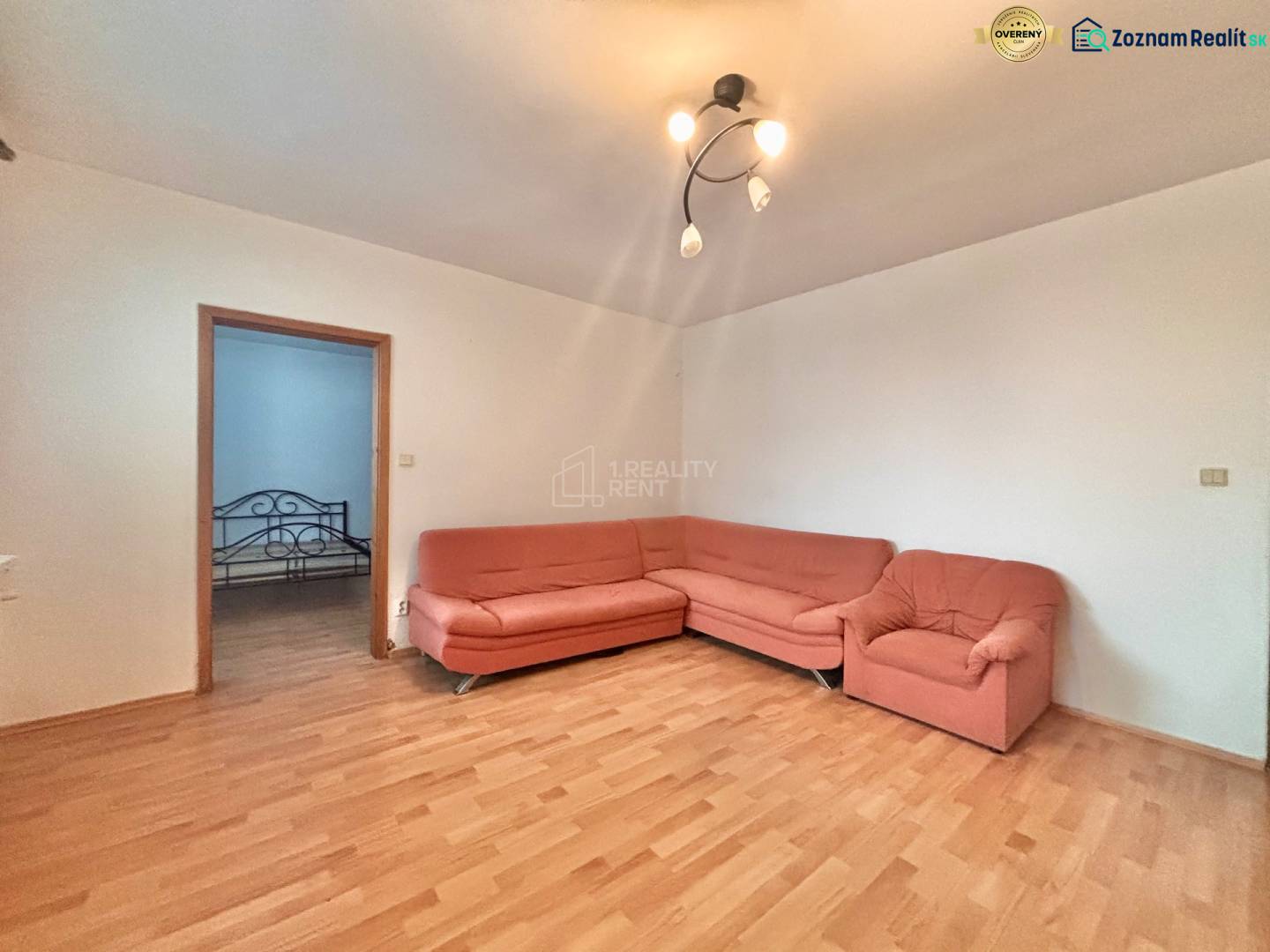 Living room in a 3-room apartment with a wooden decor floor and an orange sofa.