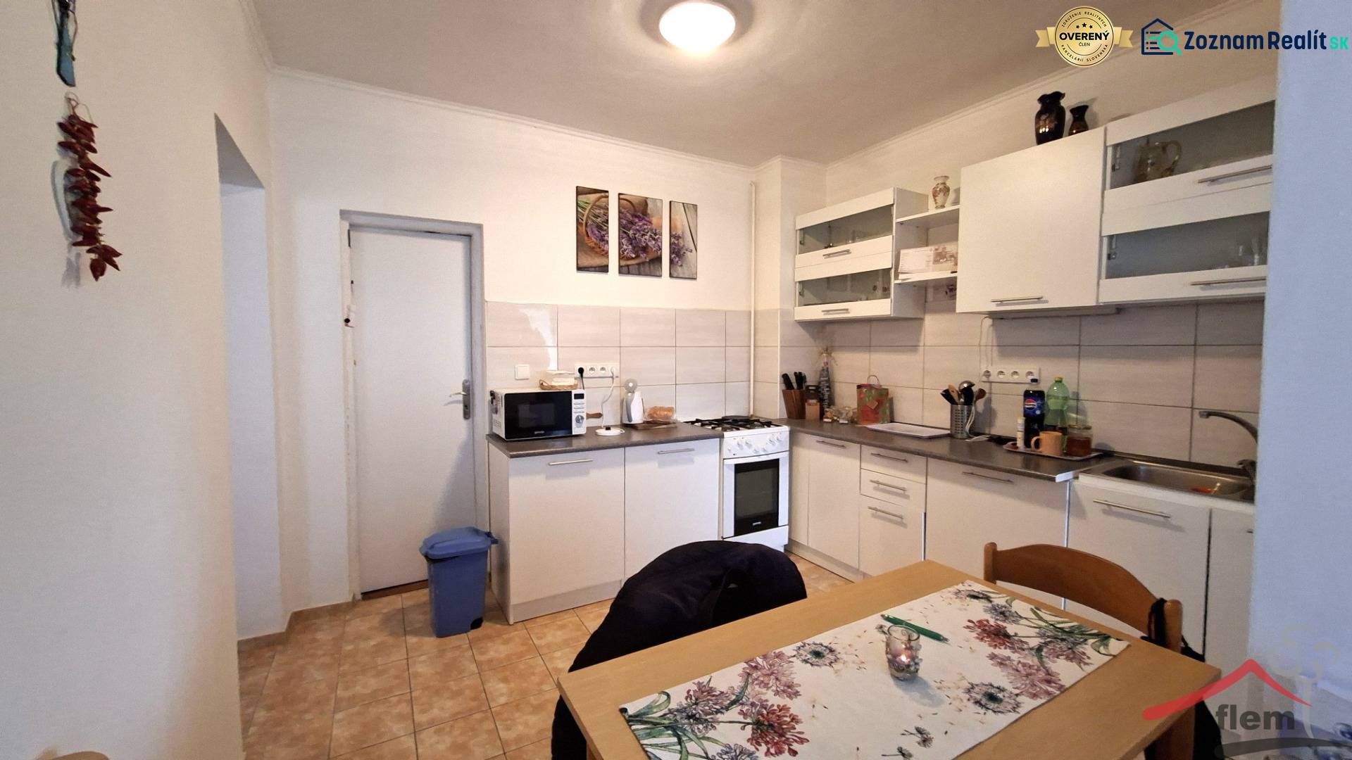 A kitchen in a family house with white furniture, a stove, and a dining table.
