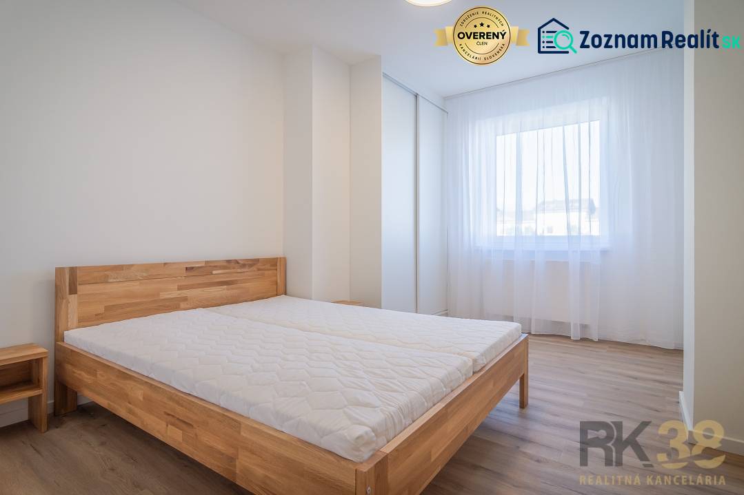 Bright bedroom with a wooden bed and a window in a 2-room apartment.