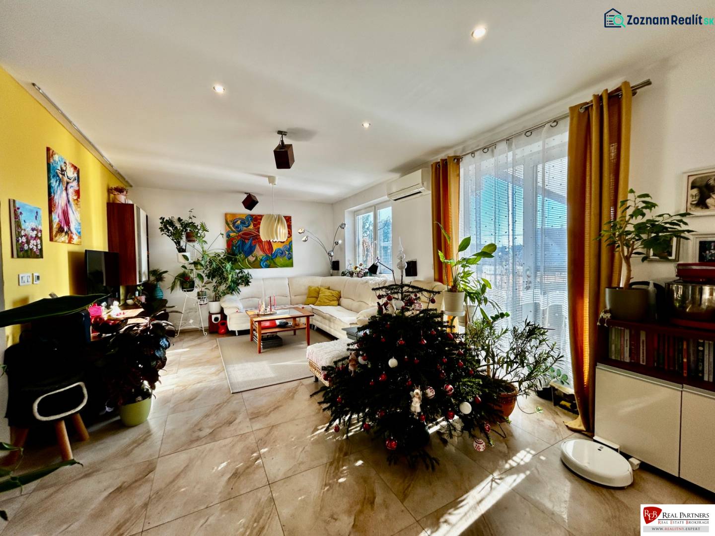 Living room with a sofa set, decorative plants, and a Christmas tree, 4-room apartment.