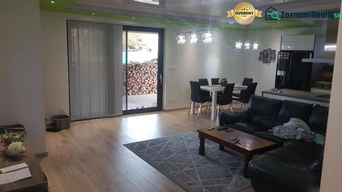 Living room in a family house with a wooden decor floor, sofa, and dining table.