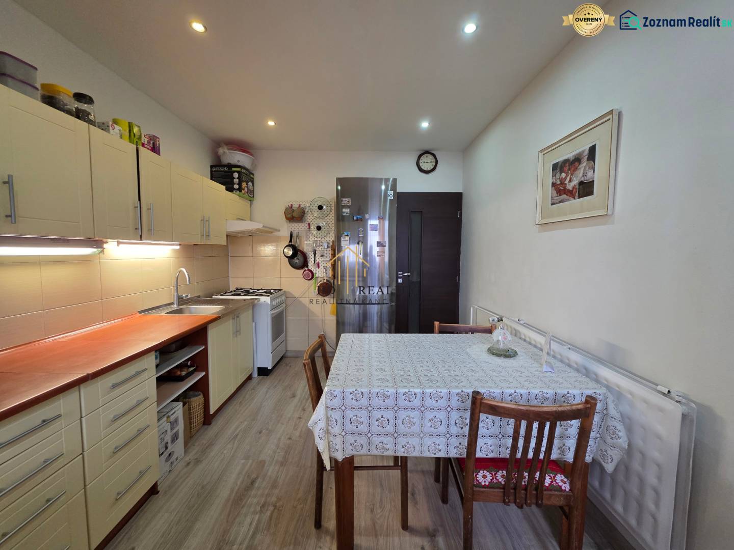 A kitchen in a 3-room apartment with a wooden decor floor and a dining table.