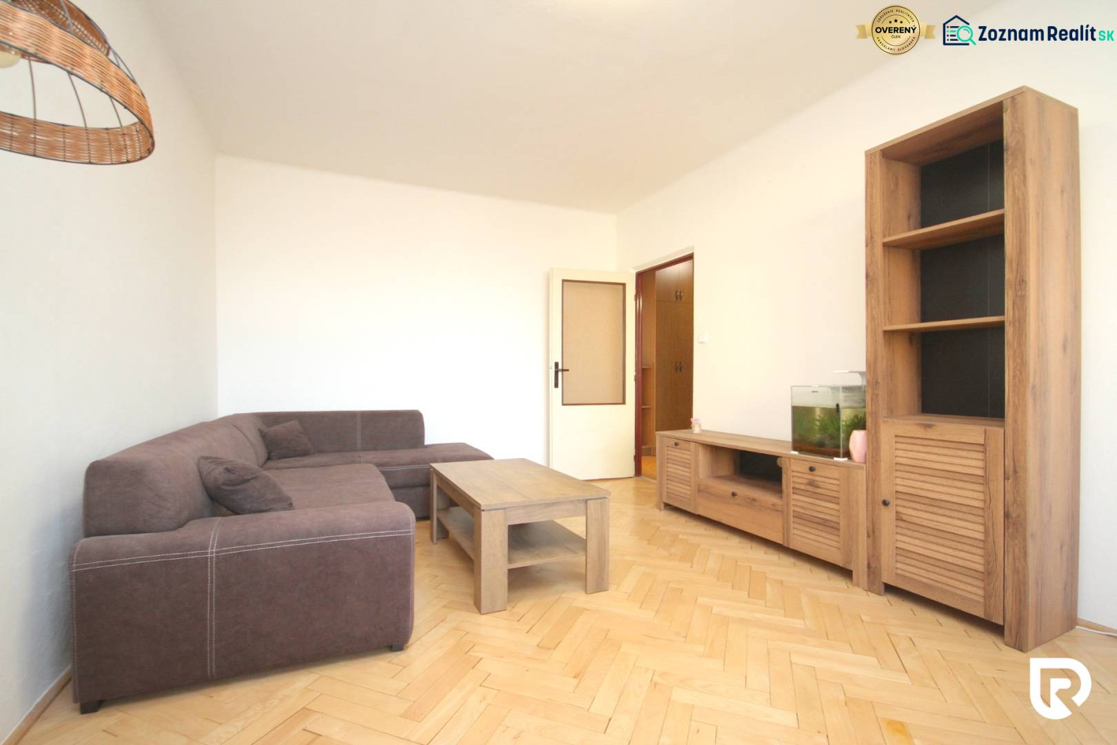 Living room in a two-room apartment with a corner sofa and a floor with a wooden decor.