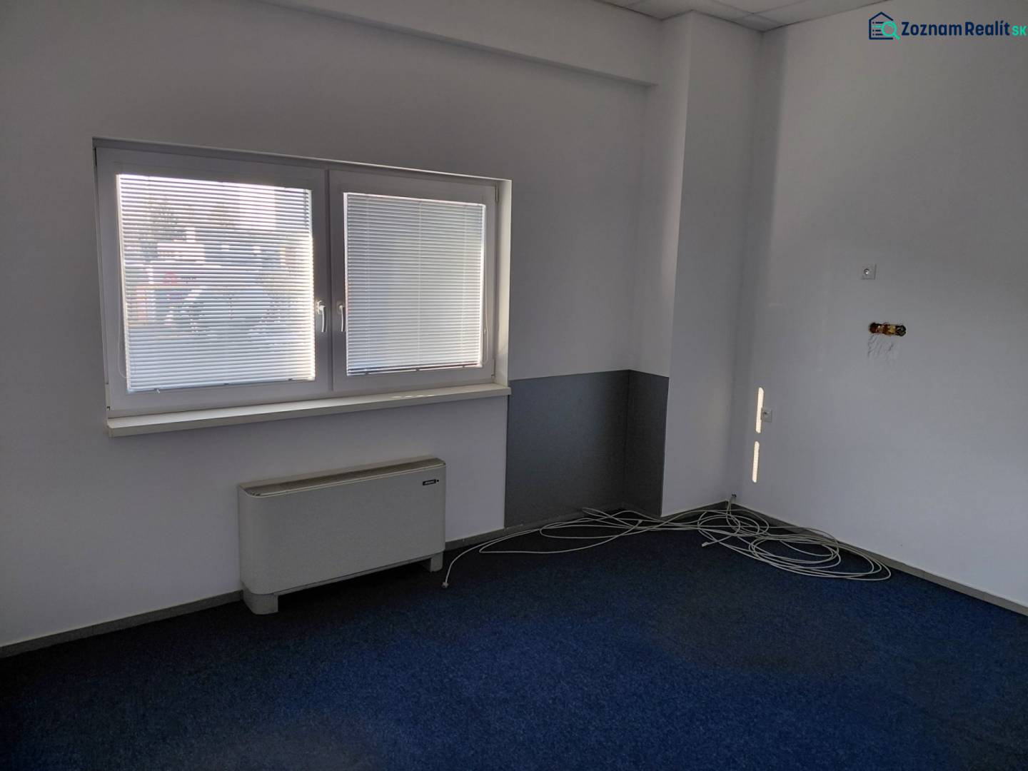Room in Warehouses and Halls, blue carpet, blinds on the window, cables by the wall.