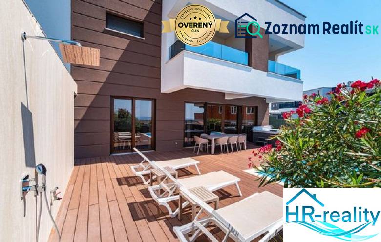 Terrace with loungers at the villa in Novalja with a sea view and a shower.