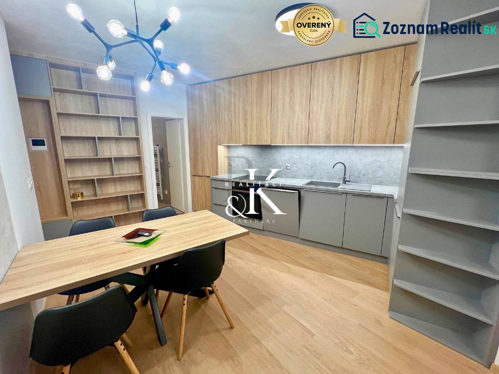 Kitchen and dining room in a 2-room apartment with a wood-patterned floor and shelves.