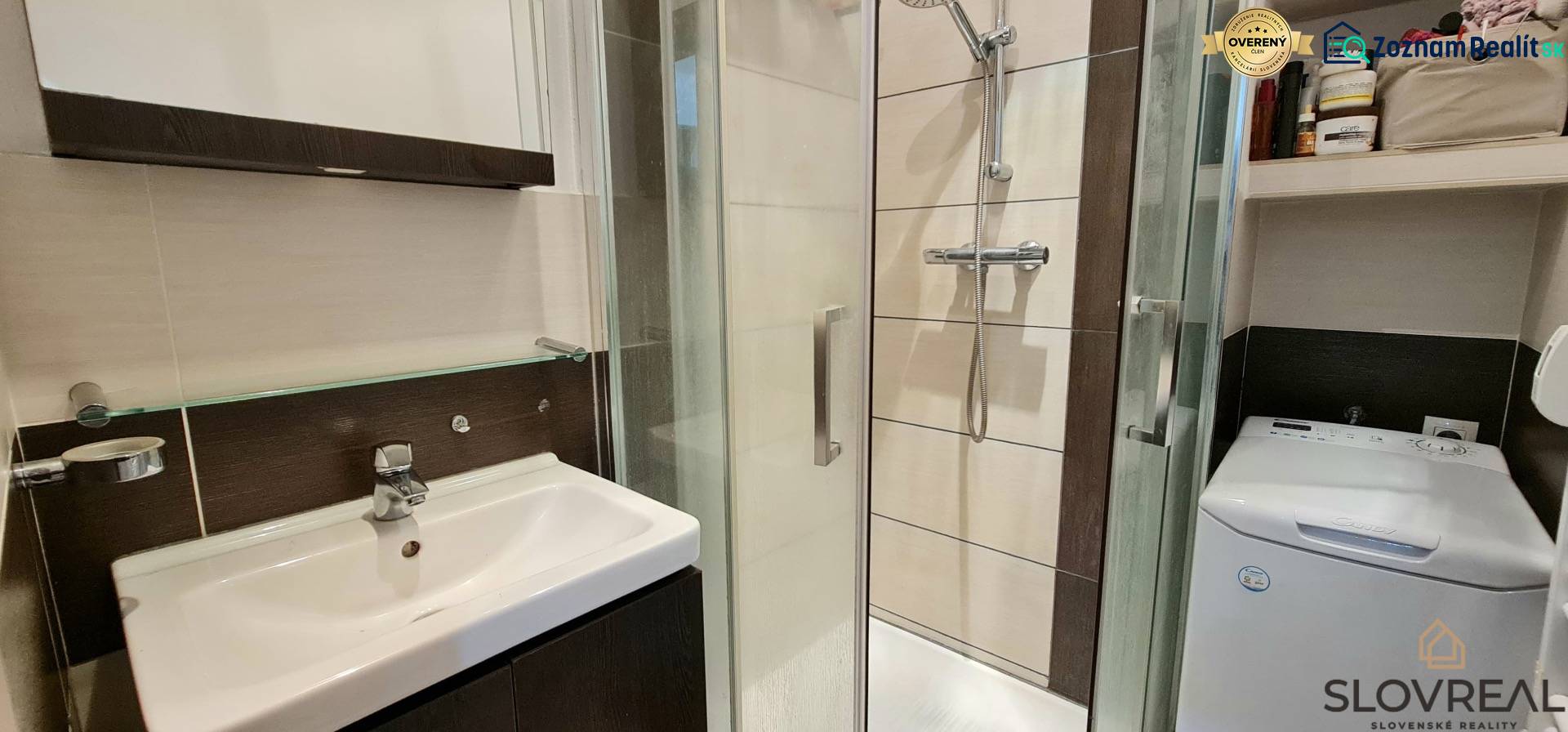 Bathroom in a 2-room apartment with a shower, sink, and washing machine.